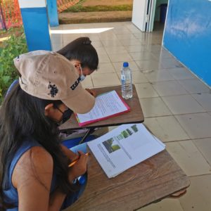 Berta a volunteer tutor helps a student complete assignments to finish teh school year.